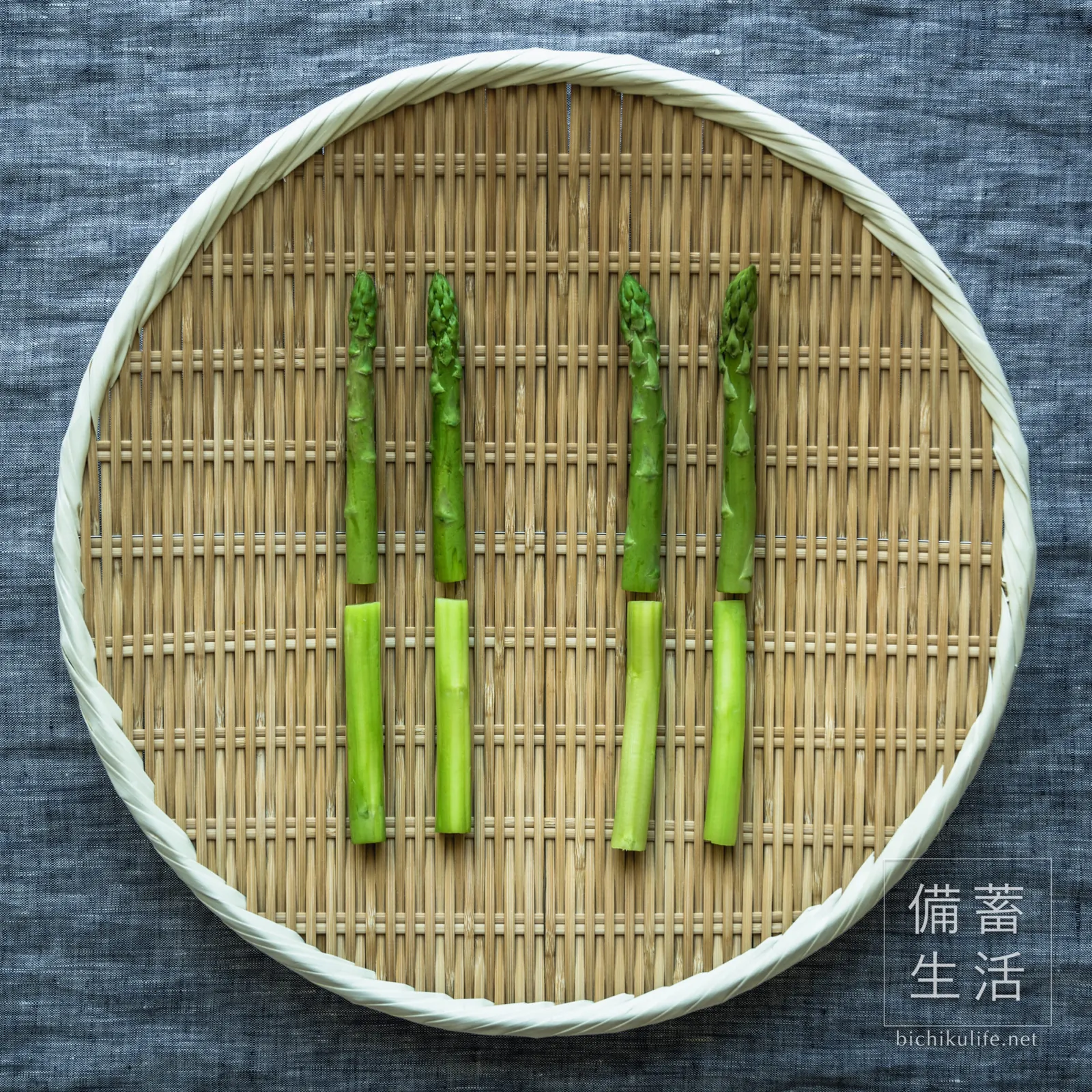 ざるに並べたアスパラガス。左の2本はゆでたもの、右の2本は生