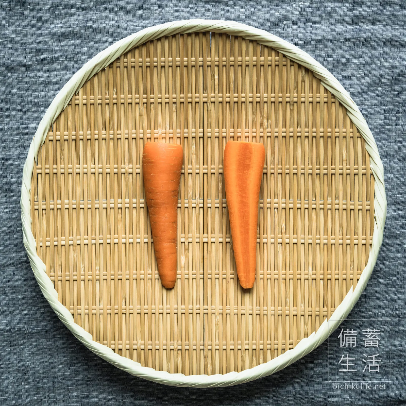ヘタと先を落として縦半分に切り、ざるに並べた人参