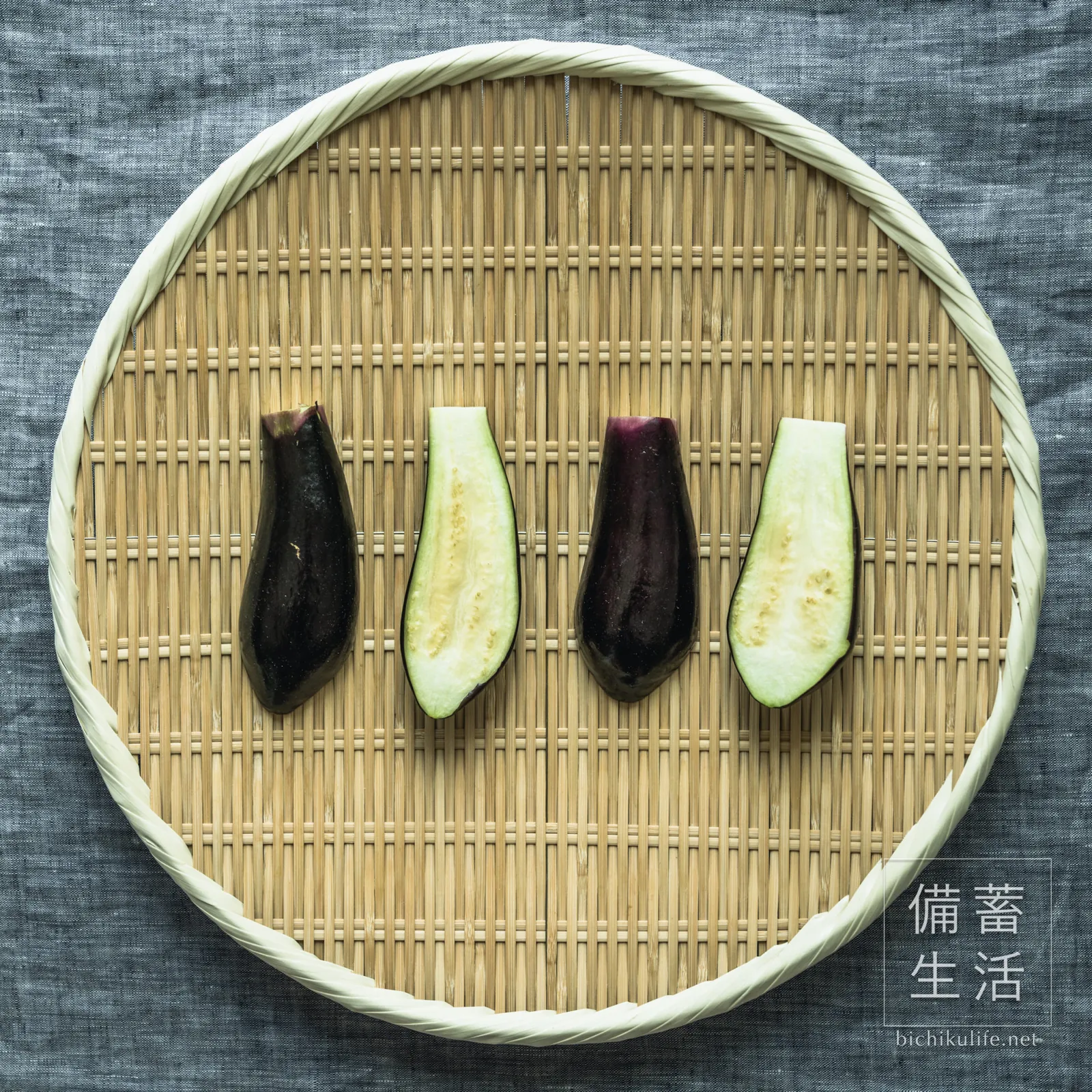 ヘタを落として縦半分に切り、ざるに並べたなす
