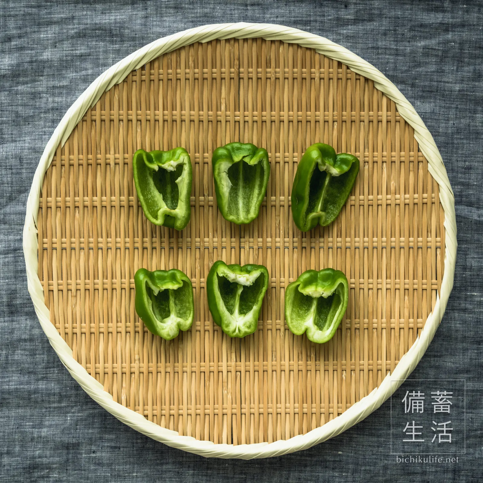 縦半分に切って種を取り、ざるに並べたピーマン