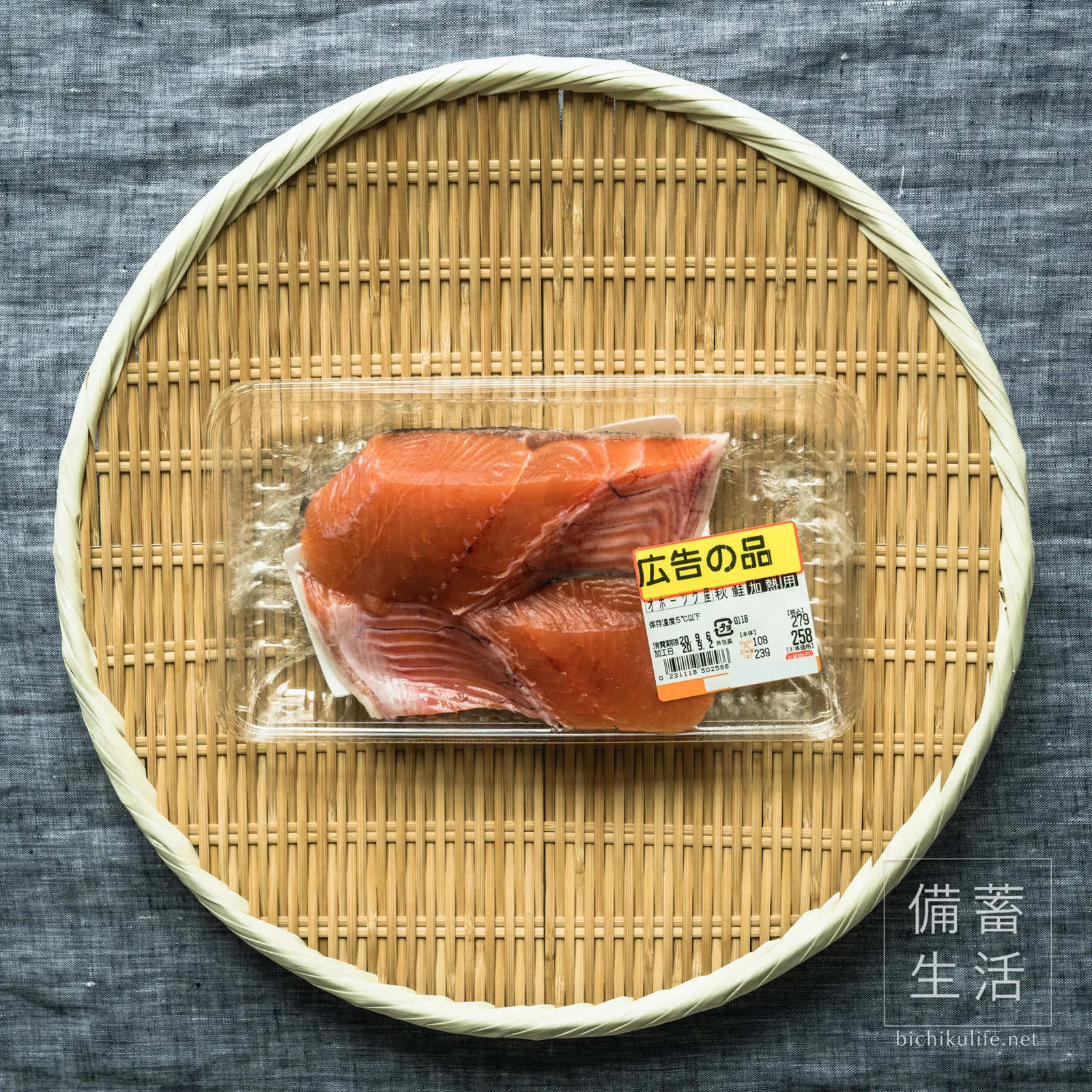 ざるにのせた、パック入りの秋鮭の切り身