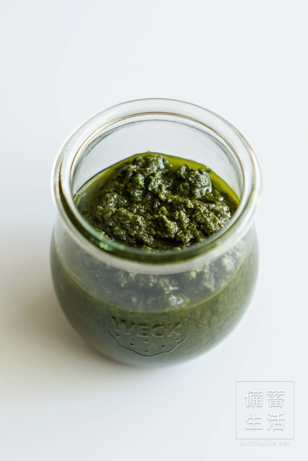 Spooning basil paste into a jar